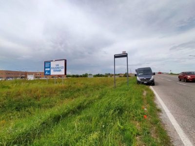 Strada città di Ferrara con traffico e poster con affissione pubblicitaria